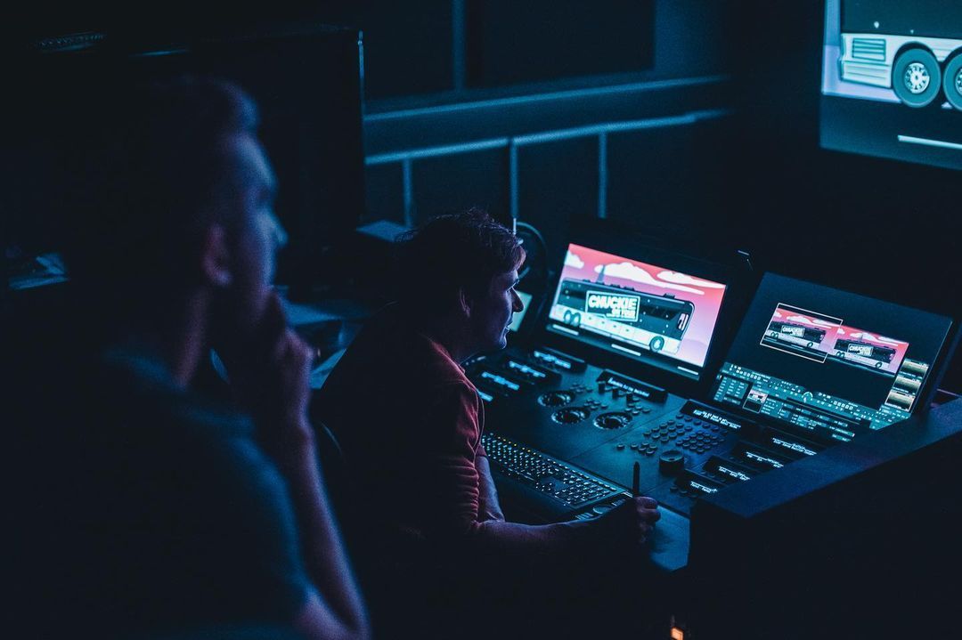 A grading session at De Grot: colorist and client in a dark suite, monitors lit